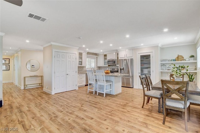 925 Alan Shepard St, Las Vegas, NV 89145 - kitchen with stainless steel appliances, a center island, crown molding, light wood-style floors, and recessed lighting