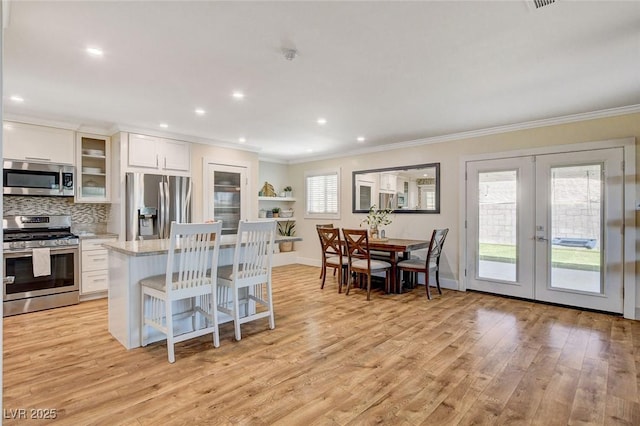 925 Alan Shepard St, Las Vegas, NV 89145 - kitchen with stainless steel appliances, ornamental molding, french doors, light wood finished floors, and white cabinetry