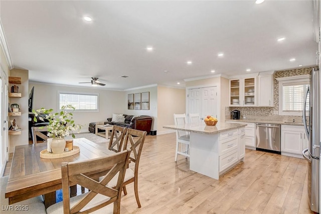 925 Alan Shepard St, Las Vegas, NV 89145 - kitchen featuring stainless steel appliances, ornamental molding, white cabinetry, a ceiling fan, and a center island