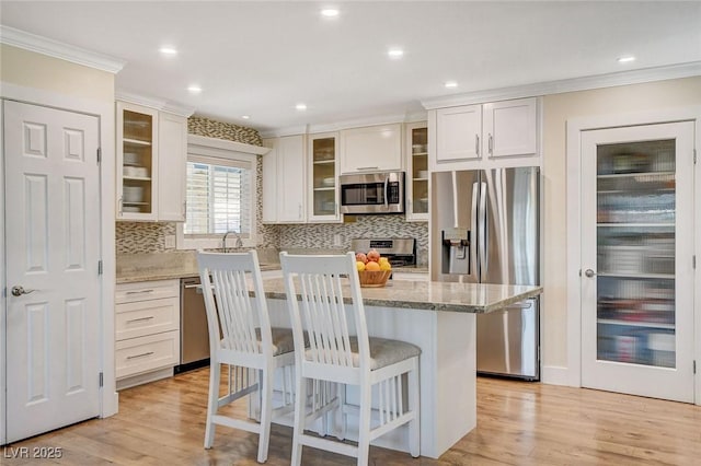 925 Alan Shepard St, Las Vegas, NV 89145 - kitchen featuring stainless steel appliances, crown molding, decorative backsplash, a kitchen bar, and a center island