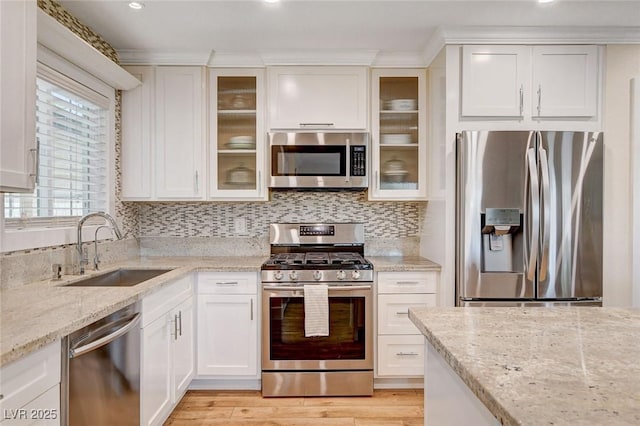 925 Alan Shepard St, Las Vegas, NV 89145 - kitchen featuring appliances with stainless steel finishes, white cabinetry, light stone counters, backsplash, and ornamental molding