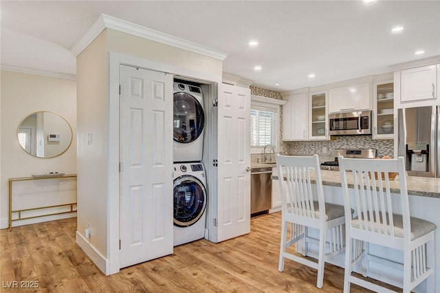 925 Alan Shepard St, Las Vegas, NV 89145 - laundry area featuring stacked washer / dryer, ornamental molding, light wood-style floors, and recessed lighting