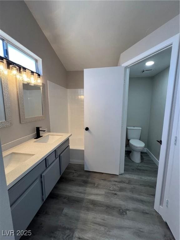 3238 Canyon Terrace Dr, Laughlin, NV 89029 - bathroom featuring double vanity, wood finished floors, vaulted ceiling, and a tub