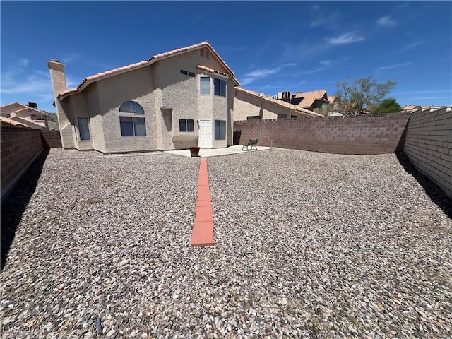 3238 Canyon Terrace Dr, Laughlin, NV 89029 - rear view of property with a tiled roof, stucco siding, a fenced backyard, and a patio