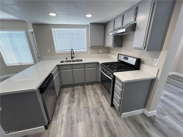 3238 Canyon Terrace Dr, Laughlin, NV 89029 - kitchen featuring gray cabinetry, appliances with stainless steel finishes, under cabinet range hood, a textured ceiling, and light wood-style floors