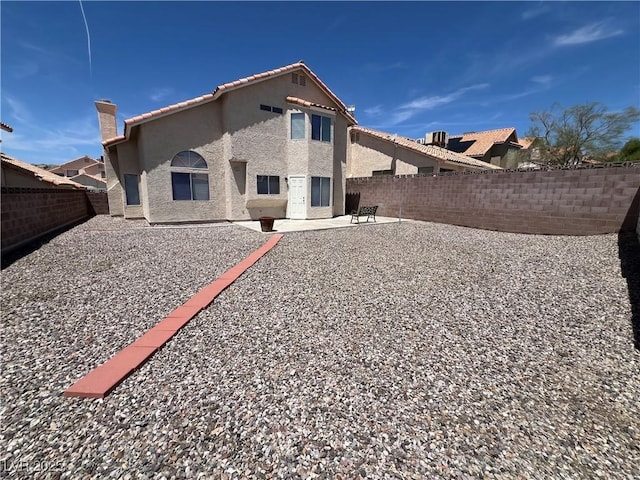 3238 Canyon Terrace Dr, Laughlin, NV 89029 - rear view of property with stucco siding, a fenced backyard, a tiled roof, a patio area, and a chimney