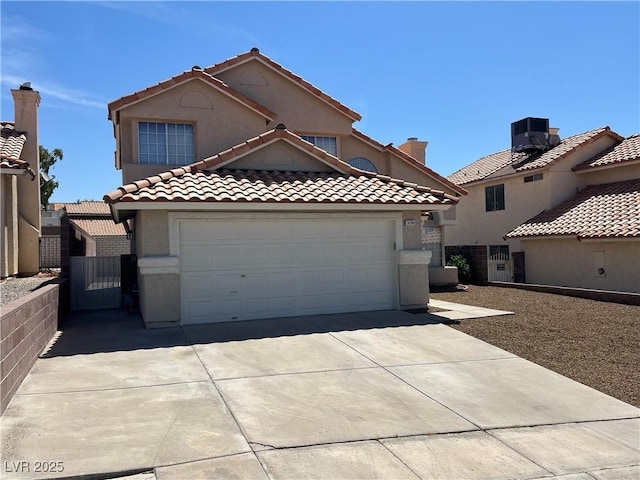 3238 Canyon Terrace Dr, Laughlin, NV 89029 - mediterranean / spanish-style home featuring concrete driveway, a gate, a tile roof, stucco siding, and a garage