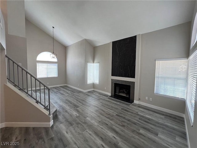 3238 Canyon Terrace Dr, Laughlin, NV 89029 - unfurnished living room featuring stairway, wood finished floors, a premium fireplace, and high vaulted ceiling