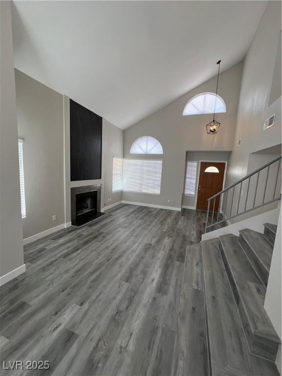 3238 Canyon Terrace Dr, Laughlin, NV 89029 - unfurnished living room with wood finished floors, stairway, high vaulted ceiling, and a large fireplace