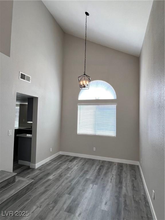 3238 Canyon Terrace Dr, Laughlin, NV 89029 - empty room featuring high vaulted ceiling, dark wood-type flooring, and a chandelier