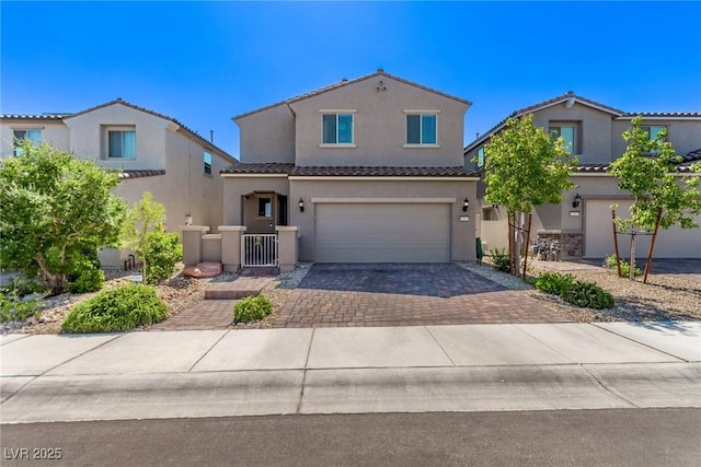 6313 Voss St, North Las Vegas, NV 89081 - mediterranean / spanish home featuring decorative driveway, a tiled roof, a garage, and stucco siding