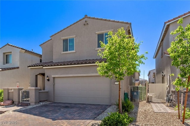 6313 Voss St, North Las Vegas, NV 89081 - mediterranean / spanish house featuring stucco siding, a tiled roof, decorative driveway, an attached garage, and a gate