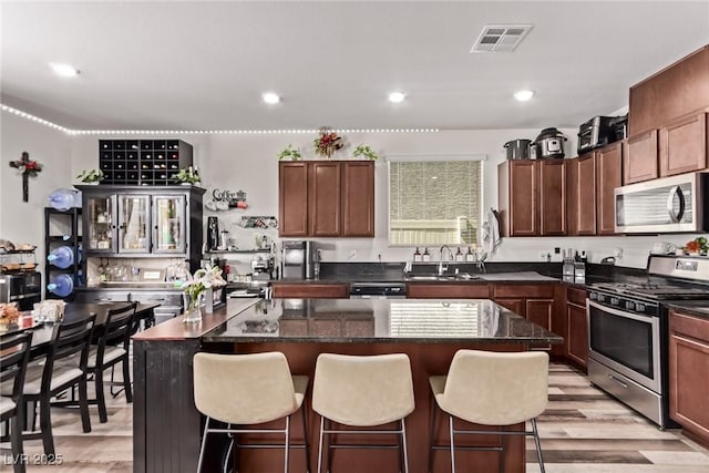 6313 Voss St, North Las Vegas, NV 89081 - kitchen featuring stainless steel appliances, a kitchen bar, light wood finished floors, a kitchen island, and recessed lighting