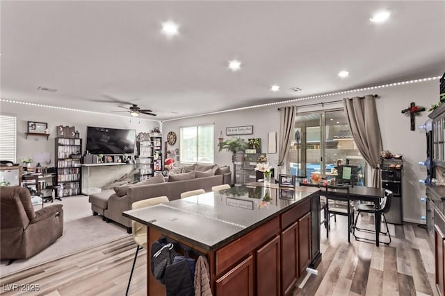 6313 Voss St, North Las Vegas, NV 89081 - kitchen with a ceiling fan, light wood-style flooring, dark countertops, a center island, and recessed lighting