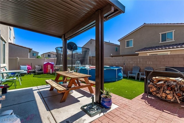 6313 Voss St, North Las Vegas, NV 89081 - fenced backyard with a trampoline, a patio area, and a residential view
