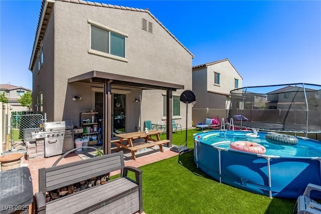 6313 Voss St, North Las Vegas, NV 89081 - rear view of property with a trampoline and stucco siding