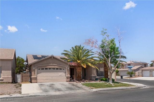1310 Ripplestone Ave, North Las Vegas, NV 89081 - view of front of house featuring an attached garage, stucco siding, driveway, solar panels, and a tile roof