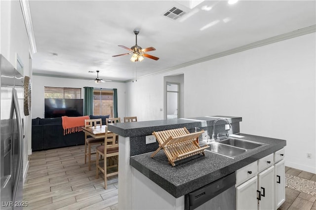 1310 Ripplestone Ave, North Las Vegas, NV 89081 - kitchen with stainless steel appliances, dark countertops, light wood-style flooring, a ceiling fan, and white cabinetry