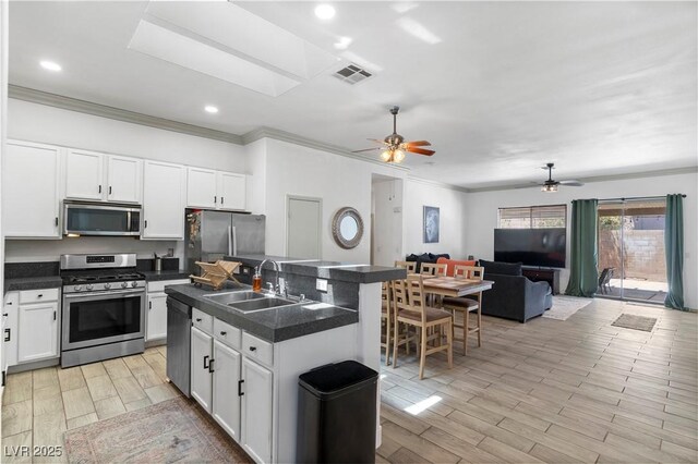 1310 Ripplestone Ave, North Las Vegas, NV 89081 - kitchen with appliances with stainless steel finishes, crown molding, dark countertops, open floor plan, and ceiling fan