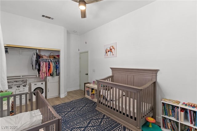 1310 Ripplestone Ave, North Las Vegas, NV 89081 - bedroom with washer / dryer, wood finished floors, a closet, a crib, and ceiling fan