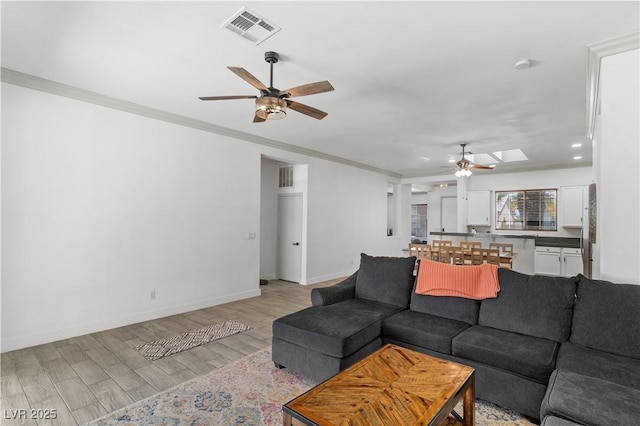 1310 Ripplestone Ave, North Las Vegas, NV 89081 - living room featuring ceiling fan, crown molding, light wood-style flooring, and a skylight