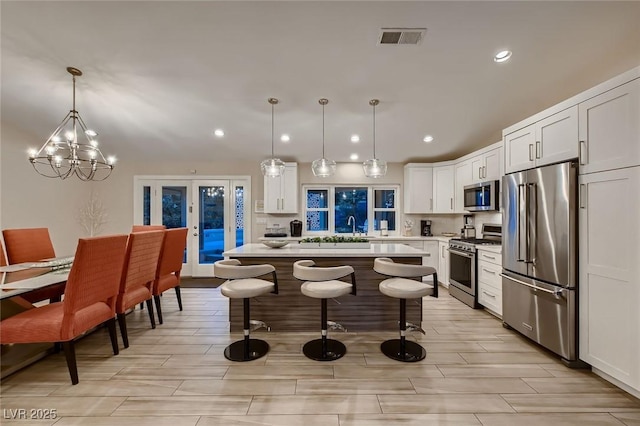 6316 Bluejay Way, Las Vegas, NV 89146 - kitchen featuring stainless steel appliances, recessed lighting, light countertops, a kitchen bar, and white cabinets