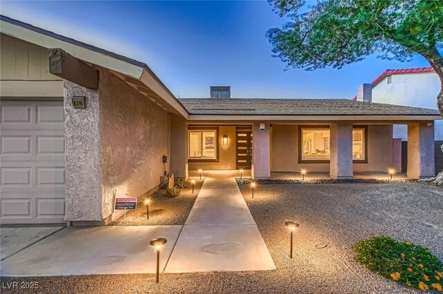 6316 Bluejay Way, Las Vegas, NV 89146 - doorway to property with a garage, stucco siding, and roof with shingles