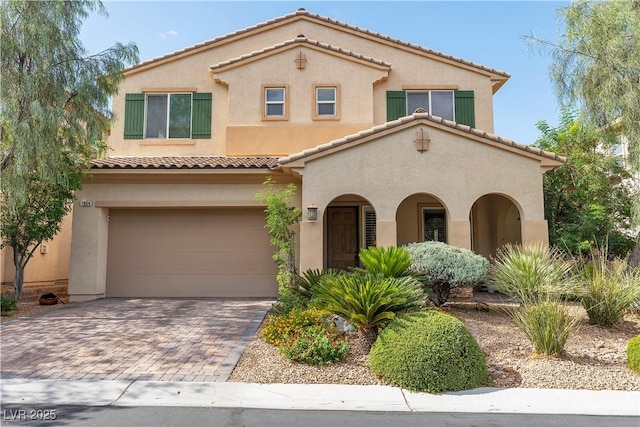 7854 Brianna Cheerful Ave, Las Vegas, NV 89178 - mediterranean / spanish-style home with stucco siding, an attached garage, decorative driveway, and a tiled roof