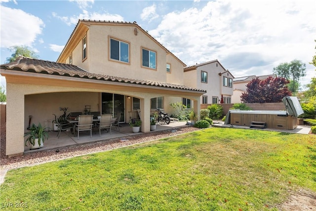 7854 Brianna Cheerful Ave, Las Vegas, NV 89178 - back of property featuring a hot tub, a patio, stucco siding, and a lawn