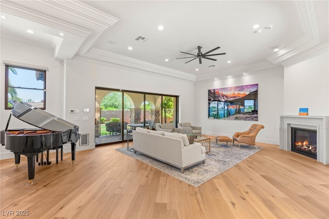 38 Pebble Dunes Ct, Las Vegas, NV 89141 - living room featuring light wood-type flooring, a ceiling fan, recessed lighting, a warm lit fireplace, and crown molding
