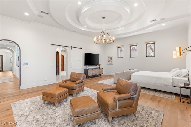 38 Pebble Dunes Ct, Las Vegas, NV 89141 - bedroom featuring arched walkways, crown molding, a barn door, recessed lighting, and light wood-style floors
