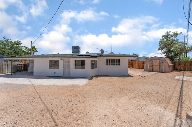 1313 Purple Sage Ave, Las Vegas, NV 89108 - rear view of house with a fenced backyard, a storage unit, roof mounted solar panels, and a patio area
