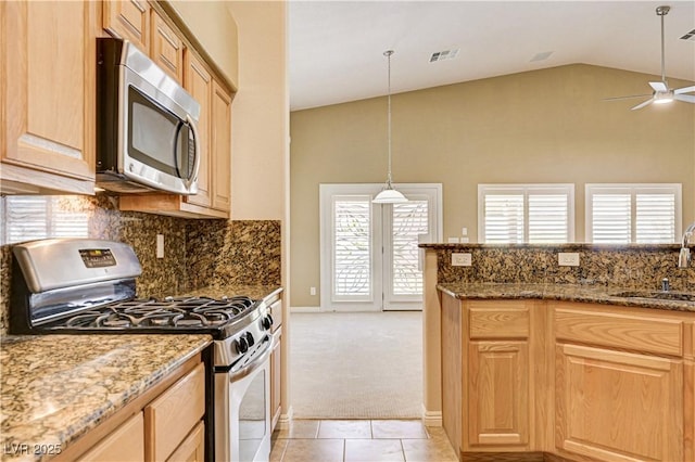 8204 Turbys Treehouse Pl, Las Vegas, NV 89131 - kitchen featuring appliances with stainless steel finishes, ceiling fan, high vaulted ceiling, light tile patterned floors, and dark stone countertops