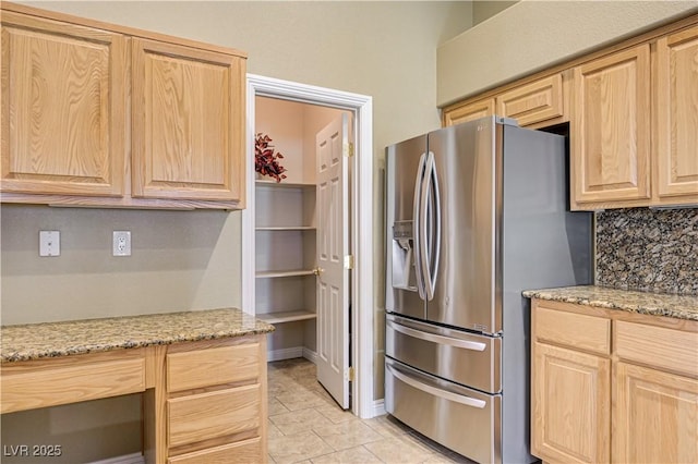 8204 Turbys Treehouse Pl, Las Vegas, NV 89131 - kitchen featuring stainless steel fridge, light brown cabinetry, light stone countertops, and backsplash