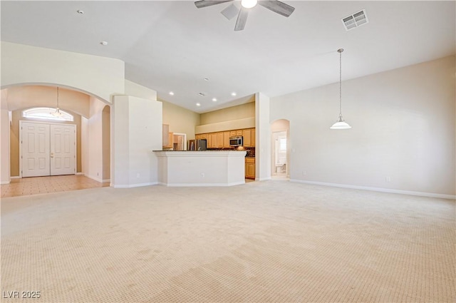 8204 Turbys Treehouse Pl, Las Vegas, NV 89131 - unfurnished living room with arched walkways, light carpet, a ceiling fan, and vaulted ceiling