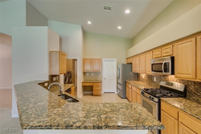 8204 Turbys Treehouse Pl, Las Vegas, NV 89131 - kitchen featuring stainless steel appliances, light brown cabinetry, a towering ceiling, stone countertops, and backsplash