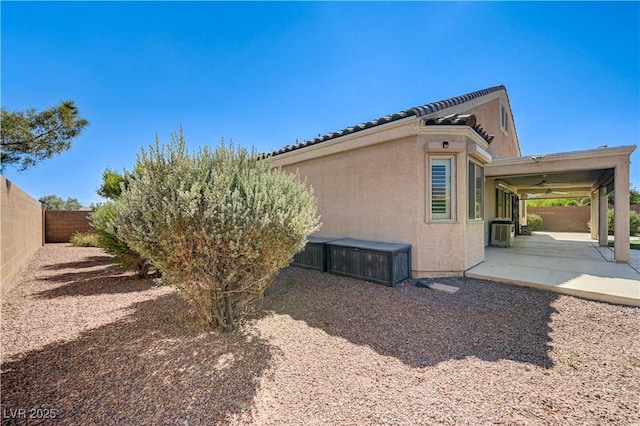8204 Turbys Treehouse Pl, Las Vegas, NV 89131 - view of side of home featuring a patio, a ceiling fan, a fenced backyard, and stucco siding