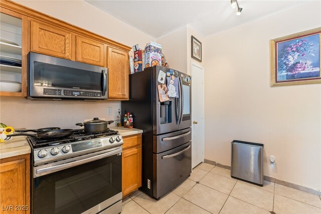 3108 Sentimental Ct, North Las Vegas, NV 89031 - kitchen with appliances with stainless steel finishes, light countertops, and brown cabinetry