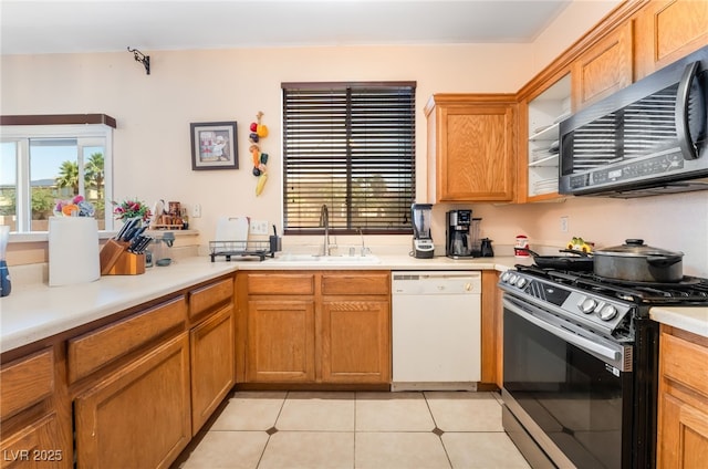 3108 Sentimental Ct, North Las Vegas, NV 89031 - kitchen with appliances with stainless steel finishes, light countertops, light tile patterned flooring, and brown cabinetry