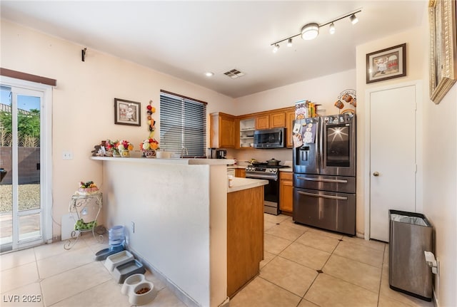 3108 Sentimental Ct, North Las Vegas, NV 89031 - kitchen featuring appliances with stainless steel finishes, light countertops, brown cabinets, and light tile patterned floors