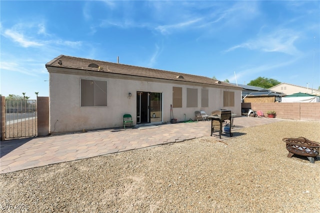 3108 Sentimental Ct, North Las Vegas, NV 89031 - rear view of house with an outdoor fire pit, a patio, stucco siding, and a gate