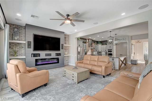 2333 Indigo Island St, Henderson, NV 89044 - living room featuring a ceiling fan, a fireplace, light wood-style flooring, and recessed lighting