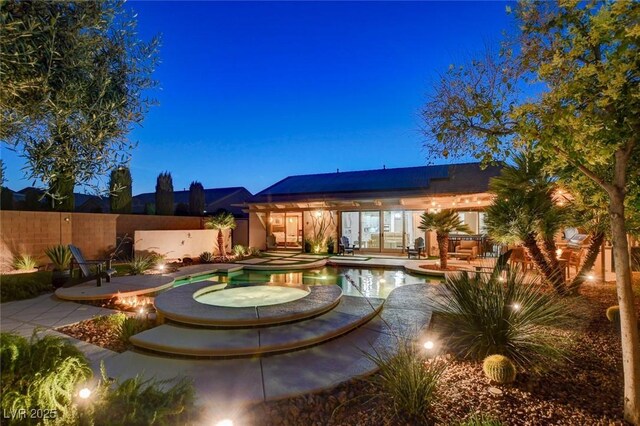 2333 Indigo Island St, Henderson, NV 89044 - back of property featuring roof mounted solar panels, a patio area, and a pool with connected hot tub