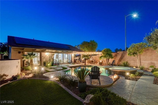 2333 Indigo Island St, Henderson, NV 89044 - pool at night featuring a patio area and a pool with connected hot tub
