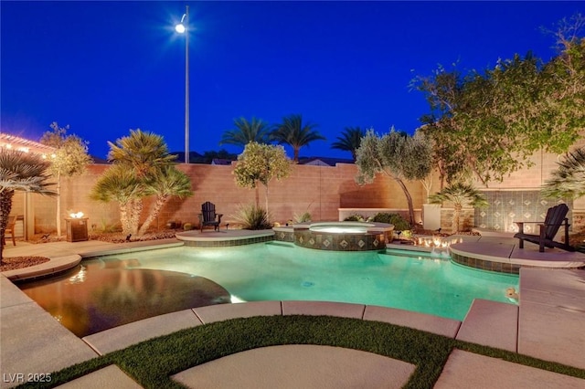 2333 Indigo Island St, Henderson, NV 89044 - pool at night featuring a fenced backyard, a pool with connected hot tub, and a patio