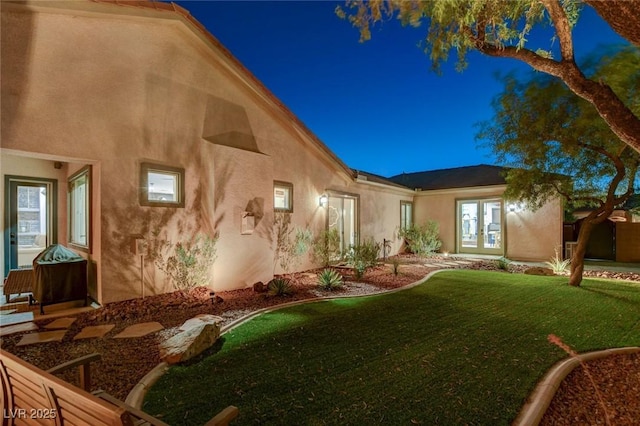 2333 Indigo Island St, Henderson, NV 89044 - rear view of house featuring french doors, stucco siding, and a lawn