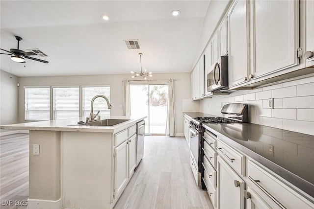 9514 Teton Vista Ave, Las Vegas, NV 89117 - kitchen with stainless steel appliances, light wood-type flooring, tasteful backsplash, an island with sink, and a chandelier