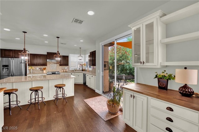 326 Caneflower Ct, North Las Vegas, NV 89031 - kitchen with stainless steel refrigerator with ice dispenser, tasteful backsplash, dishwashing machine, glass insert cabinets, and recessed lighting