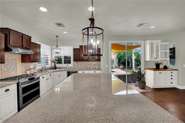 326 Caneflower Ct, North Las Vegas, NV 89031 - kitchen featuring range with two ovens, under cabinet range hood, light stone counters, tasteful backsplash, and white cabinets