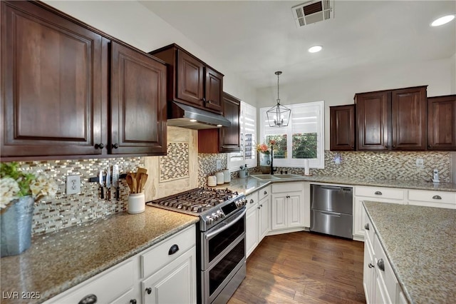 326 Caneflower Ct, North Las Vegas, NV 89031 - kitchen with stainless steel appliances, under cabinet range hood, dark wood-style floors, light stone counters, and dark brown cabinetry